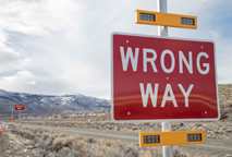 A road sign showing "wrong way"